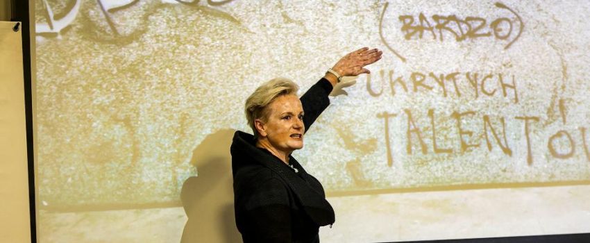 Artystka na tle wyświetlanego obrazu.