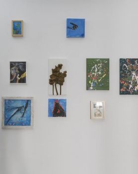 Na białej ścianie wiszą obrazy