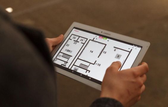 w centralnej części zdjęcia znajdują się dłonie, które trzymają włączony tablet