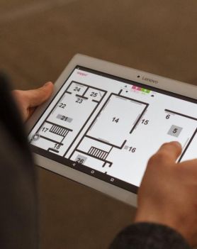 w centralnej części zdjęcia znajdują się dłonie, które trzymają włączony tablet