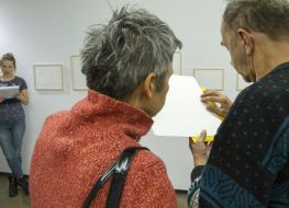 Kobieta i mężczyzna dotykają matrycy graficznej, podczas oprowadzania po wystawie.
